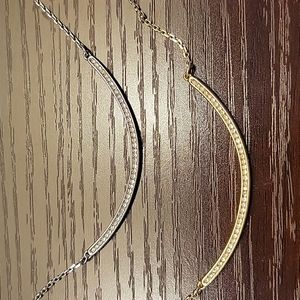 Silver and gold finish arc necklaces.